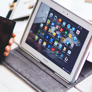 Person holding a phone while using a tablet computer