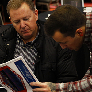 Two people reading from the same brochure