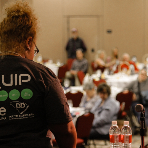 Woman speaking to a full room