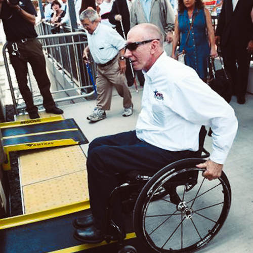 Man in wheelchair using ramp into subway