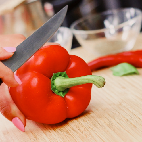 Knife cutting red pepper