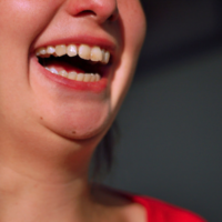 Healthy Reactions session icon: Lower half of woman's face with open-mouthed, toothy smile.