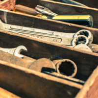 Maintenance session icon: Rusty wrenches in a worn wooden toolbox