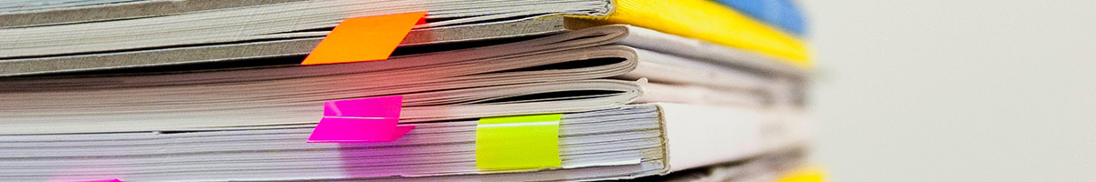 Stack of books with post-it note bookmarks