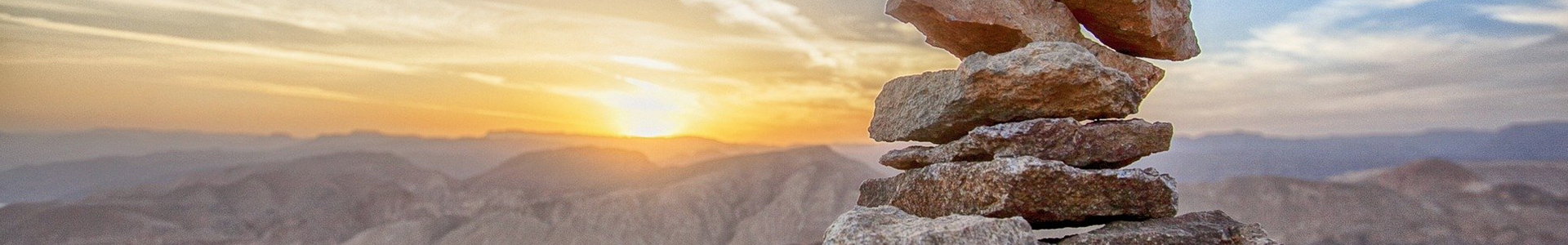 The Great Balancing Act banner: Rocks stacked on top of each other with a sunset in the background