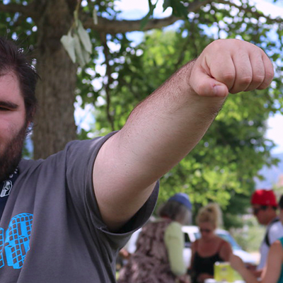 Young man stands in a superhero pose with his arm outstretched and his hand in fist