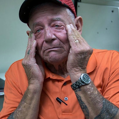 Man with a distressed look on his face rubs the side of his face