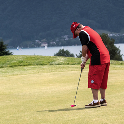 Young man with a disability putting on a golf course